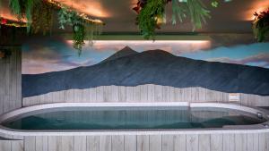 een zwembad met een muurschildering van een berg bij Logis Hôtel Restaurant & Spa les Remparts in Salers