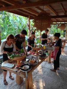 um grupo de pessoas à volta de uma mesa com comida em Villa Adi em Amed