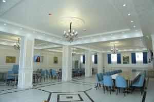 a dining room with a table and blue chairs at Гостиница Тумор in Shahrisabz