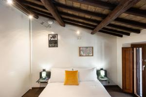 a bedroom with a white bed with two lamps at Mou Trastevere House by Rental in Rome in Rome