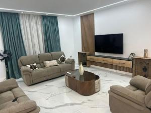 sala de estar con 2 sofás y TV de pantalla plana en شقة 200 متر جديدة بالكامل للايجار في الحى التاسع مدينة العبور القاهرة, en Obour