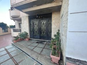 una puerta de un edificio con macetas delante de él en شقة 200 متر جديدة بالكامل للايجار في الحى التاسع مدينة العبور القاهرة, en Obour