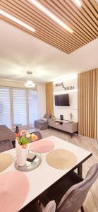 a living room with a table with chairs and a tv at Apartament Black-White in Mielno