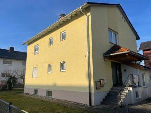 un edificio amarillo con escaleras a un lado en Ihr Zuhause fernab von Zuhause, en Ringsheim