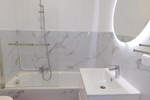 a bathroom with a shower and a sink and a tub at T2 "Les Hameaux du Soleil" with pool and parking in Villeneuve-Loubet