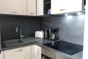 a kitchen with a sink and a counter top at T2 "Les Hameaux du Soleil" with pool and parking in Villeneuve-Loubet