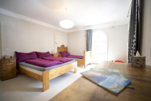 um quarto com uma cama com almofadas roxas em Villa Victoria - Nairs, Scuol em Scuol