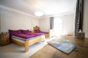 a bedroom with a bed with purple pillows at Villa Victoria - Nairs, Scuol in Scuol