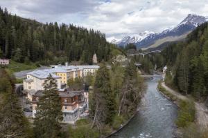 a town next to a river with mountains in the background at Villa Victoria - Nairs, Scuol in Scuol