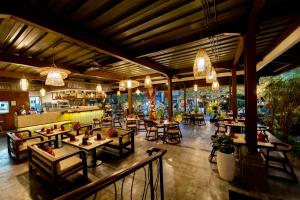a restaurant with tables and chairs and a bar at Anumana Ubud Hotel in Ubud