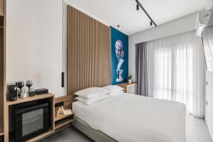 1 dormitorio con 1 cama grande y TV en The Q Hotel, en Atenas