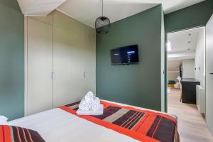 a bedroom with a bed and a tv on a wall at Hamac Suites - Le Franklin - 4 people in Lyon