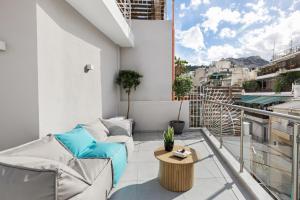 Apartment mit Balkon, Sofa und Tisch in der Unterkunft The Q Hotel in Athen