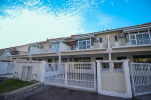 a white fence in front of a building at Rezeki Homestay@Harmonia2 Desaru in Bandar Penawar