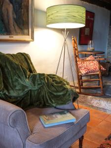 a living room with a couch with a blanket on it at Santuario Virgen de la Fuente in Peñarroya de Tastavins