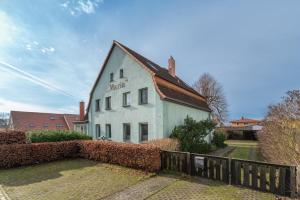 a white building with a sign on the side of it at Ferienhaus Maria 6 Schlafzimmer & Sauna in Ostseebad Koserow