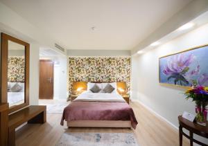 1 dormitorio con 1 cama y una pintura en la pared en Phoenicia Comfort Hotel en Bucarest