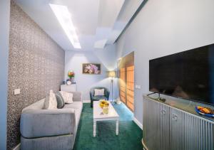 a living room with a couch and a flat screen tv at Phoenicia Comfort Hotel in Bucharest