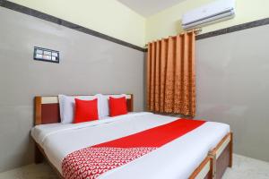 a bedroom with a bed with red and white pillows at SPOT ON Raja Lodge in Tiruvannāmalai