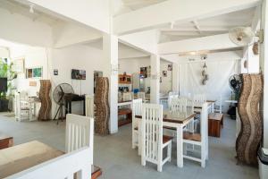 uma sala de jantar com cadeiras brancas e uma mesa em Costas De Liwa Bar & Beach Resort em Zambales