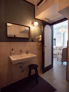 baño con lavabo, espejo y taburete en Finca Casabela, en Pinos del Valle
