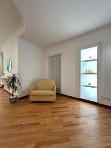 un salon vide avec une chaise et une fenêtre dans l'établissement Zeffirino Apartments, à Sanremo