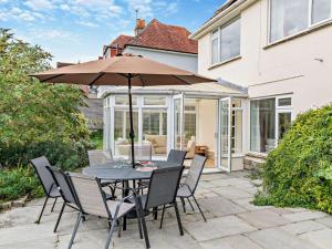 a table and chairs with an umbrella on a patio at 4 Bed in Studland 75639 in Studland
