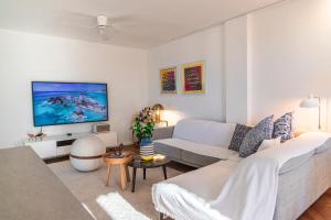 a living room with a white couch and a tv at Koper Seaside Residence in Koper