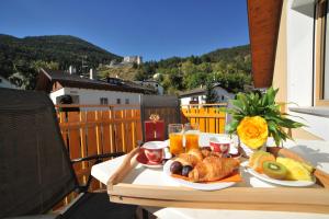 a table with food and drinks on a balcony at Suvendes Apartments in Prato allo Stelvio