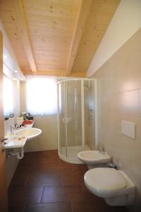 a bathroom with two sinks and a shower and a toilet at Suvendes Apartments in Prato allo Stelvio