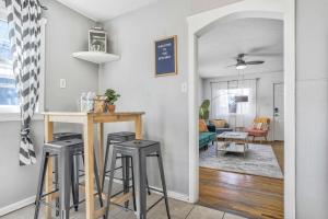 a living room with two bar stools and a kitchen at Colorado Cottage - Downtown King Scenic in Colorado Springs