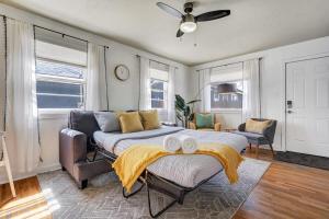 a bedroom with a bed and a couch and windows at Colorado Cottage - Downtown King Scenic in Colorado Springs
