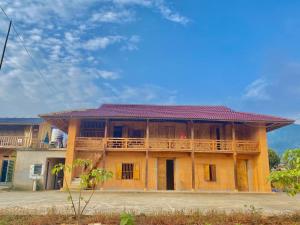 un ancien bâtiment avec un toit rouge dans l'établissement Tình Diễn homestay, à Quản Bạ