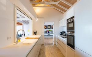 a white kitchen with a sink and a stove at Luxury Vacation Villa 16 in Pointe Milou