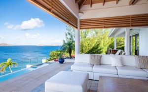 a living room with a couch and a view of the ocean at Luxury Vacation Villa 16 in Pointe Milou