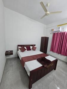 een slaapkamer met een bed en een plafondventilator bij ZEAL HOMES And Apartments Koothattukulam in Kuttāttukulam