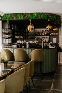 um restaurante com cadeiras e um balcão com um bar em Hotel-Restaurant La Caborne em Limonest