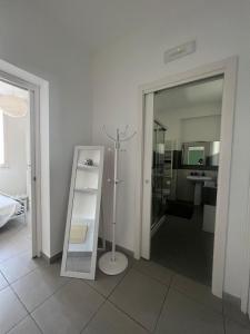 a white room with a bathroom with a mirror at Via Itria in Marsala