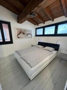 ブリッサーゴにあるCasa Malpensata App 6363の白いベッドルーム(ベッド1台、窓付)