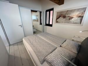 ブリッサーゴにあるCasa Malpensata App 6363のベッドルーム1室(ベッド1台付)が備わります。壁には絵画が飾られています。