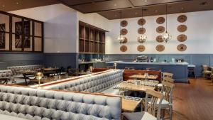 un restaurante con bancos y mesas y un bar en 23rd FL Bold CozySuites with pool, gym, roof, en Dallas