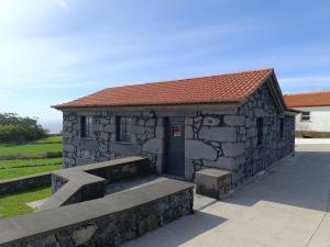 un pequeño edificio de piedra con un banco delante en Laura's Cottage AL en Velas