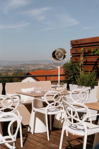 y balcón con mesa de comedor blanca y sillas. en Hotel-Restaurant La Caborne, en Limonest