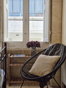 een stoel met een kussen voor een raam bij Charming Senglea Studio in Senglea