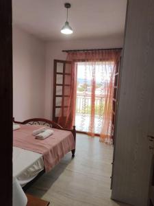 1 dormitorio con cama y ventana en Vrasna Luxury Apartment en Nea Vrasna