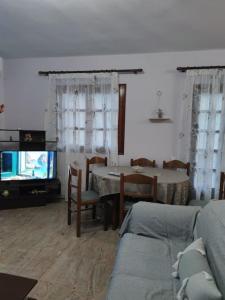 a living room with a table and a tv at Vrasna Luxury Apartment in Nea Vrasna +27 photos