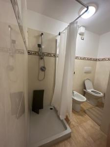 a bathroom with a toilet and a shower with a shower curtain at Appartamento spazioso in centro in Viterbo +24 photos