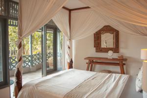 ein Schlafzimmer mit Himmelbett und Tisch in der Unterkunft Villa Holy By The Villas 100 in Bogor