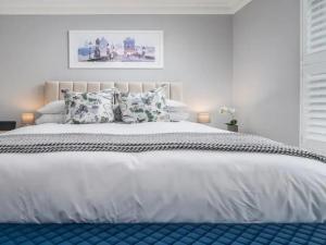ein Schlafzimmer mit einem großen weißen Bett und Kissen in der Unterkunft Pass the Keys Luxury 2 Bedroom Townhouse in Central St Albans in St Albans