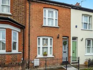 uma casa de tijolos vermelhos com uma porta verde em Pass the Keys Luxury 2 Bedroom Townhouse in Central St Albans em Saint Albans